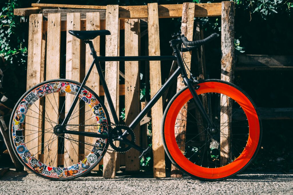 Black and Multicolored Bicycle Near Wood Fence